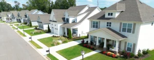 Row of homes with front porches and landscaped lawns along a residential street in Harvest, Alabama.
